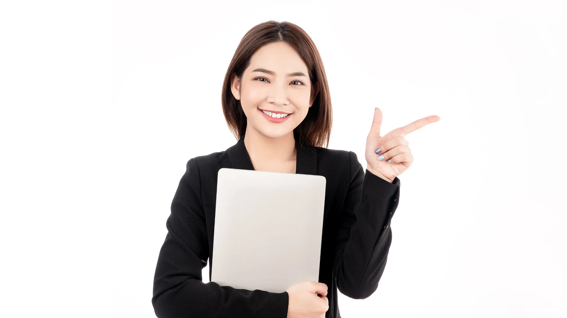 ノートPCを持ち指をさして説明するビジネススーツの女性