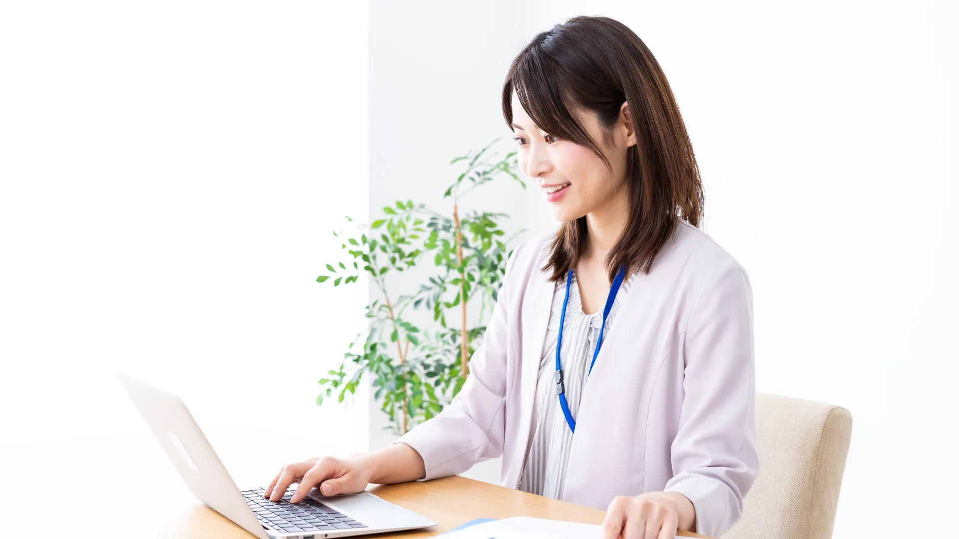 ) 女性ビジネスパーソンがパソコンで製品の情報を調べる様子。
