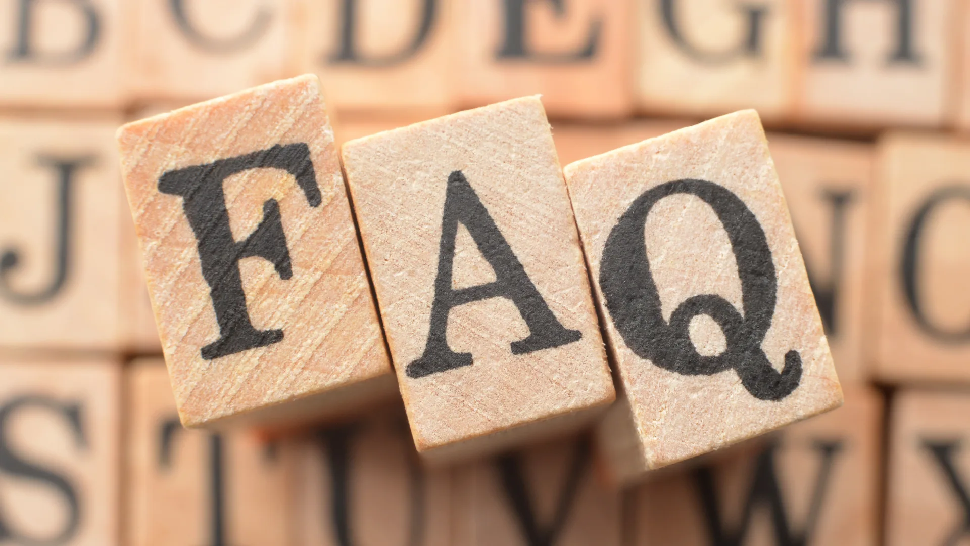 木製のブロックに大きく書かれた「FAQ」の文字