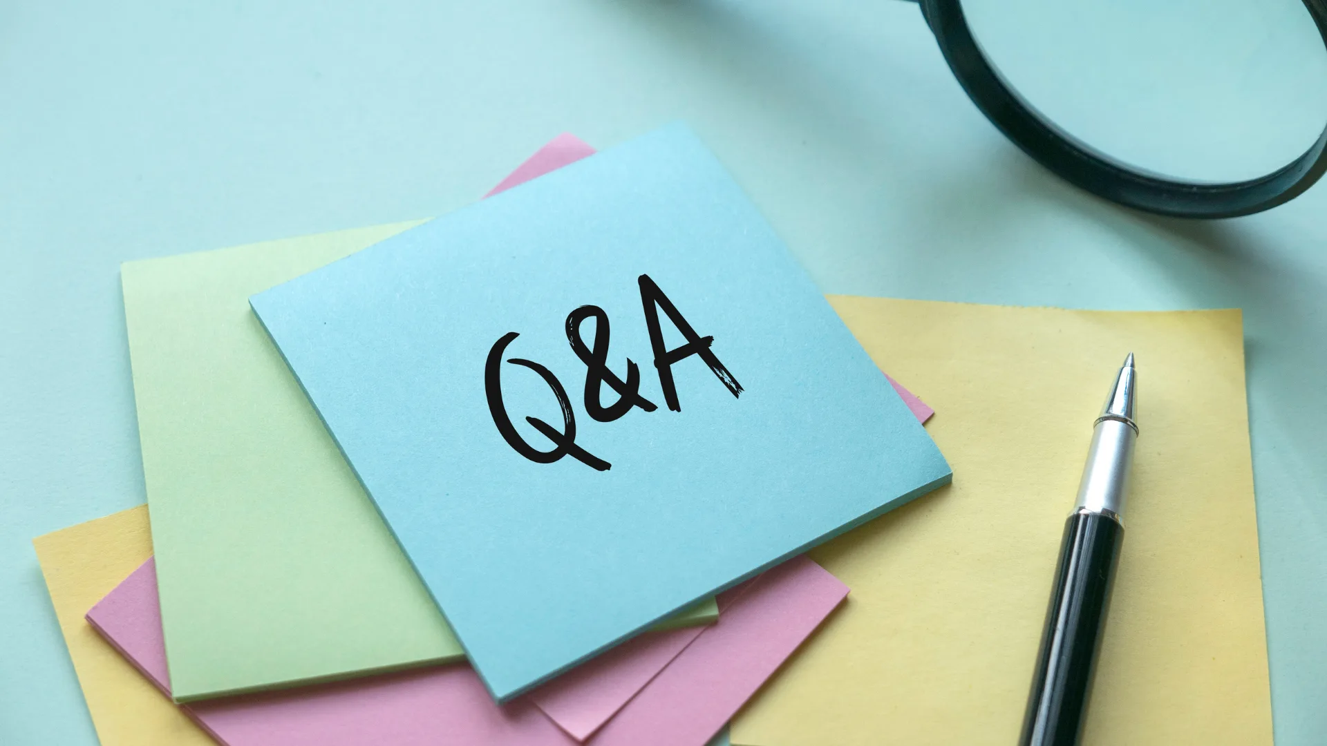 「Q&A」と書かれた付箋とペン、質問と回答のイメージ
