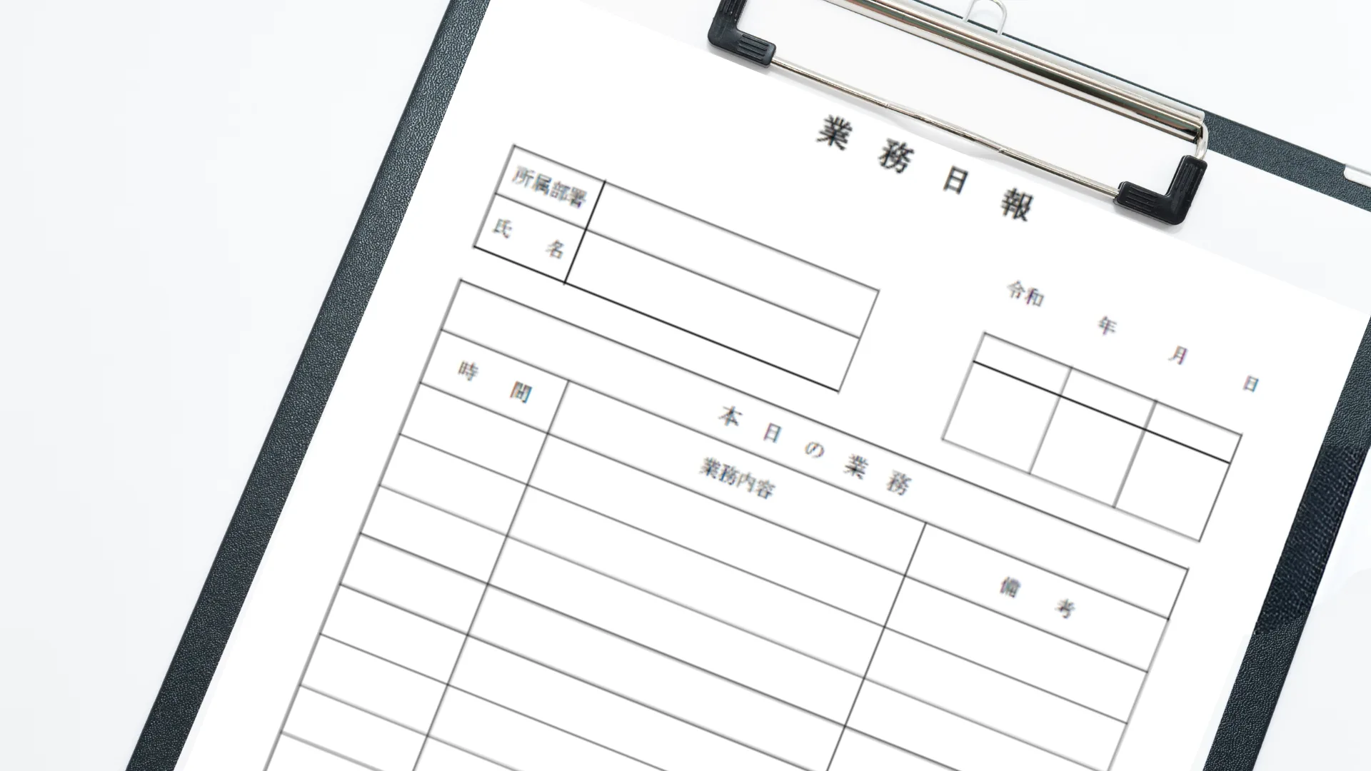 黒いバインダーに挟まれた白紙の業務日報。