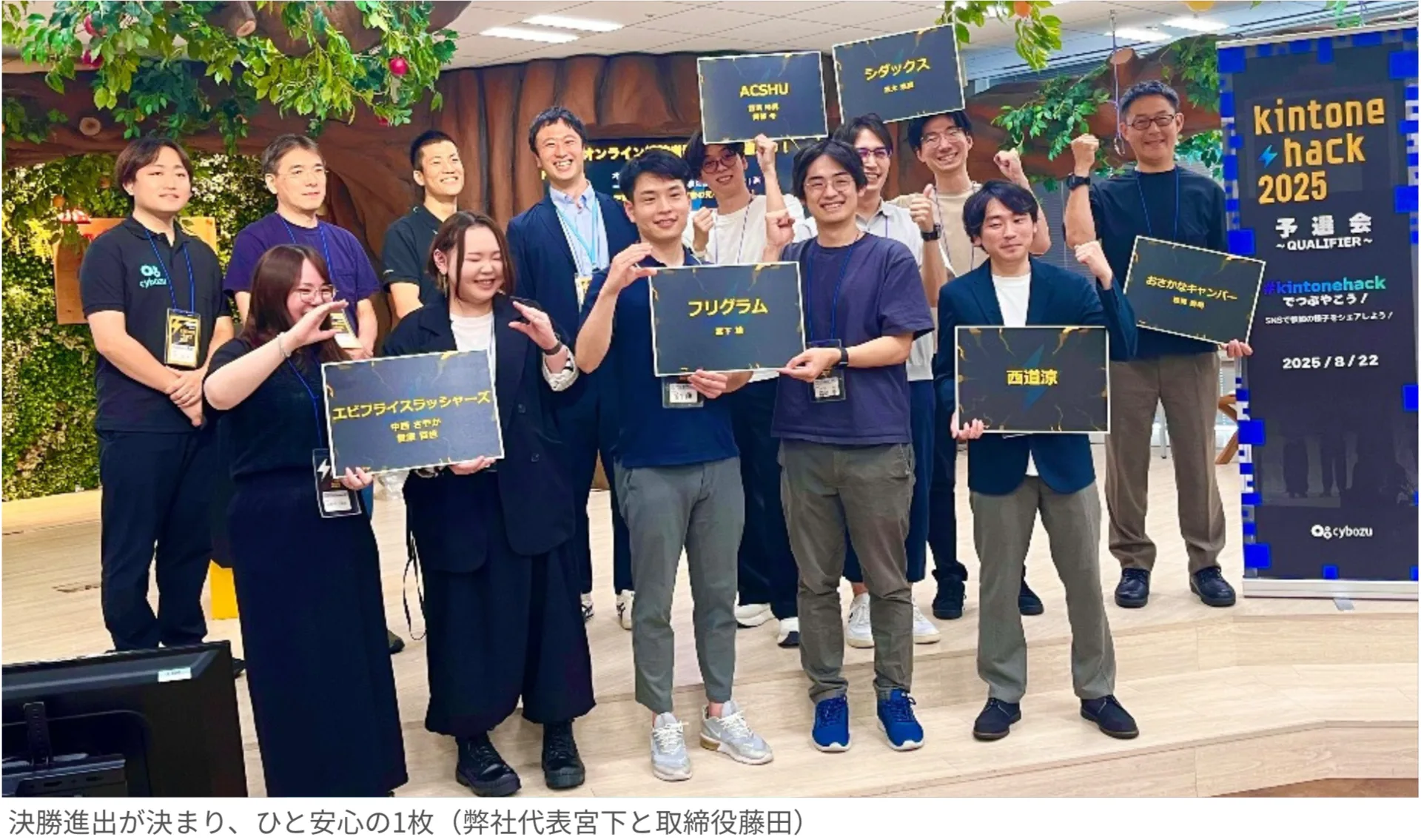 kintone hack 2025予選会にて、決勝進出チームのメンバーが各チーム名のボードを持って集合写真に収まる様子。中央にフリグラム代表 宮下と取締役 藤田の姿も見える。