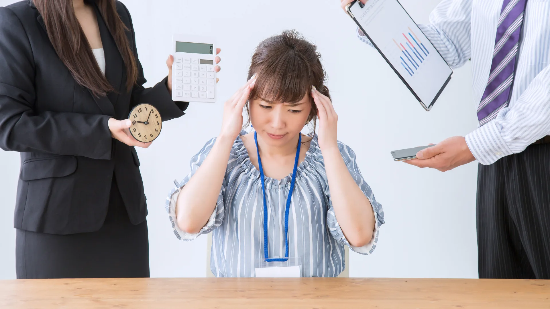 複数の人にタスクを頼まれ頭を抱える疲弊する女性社員