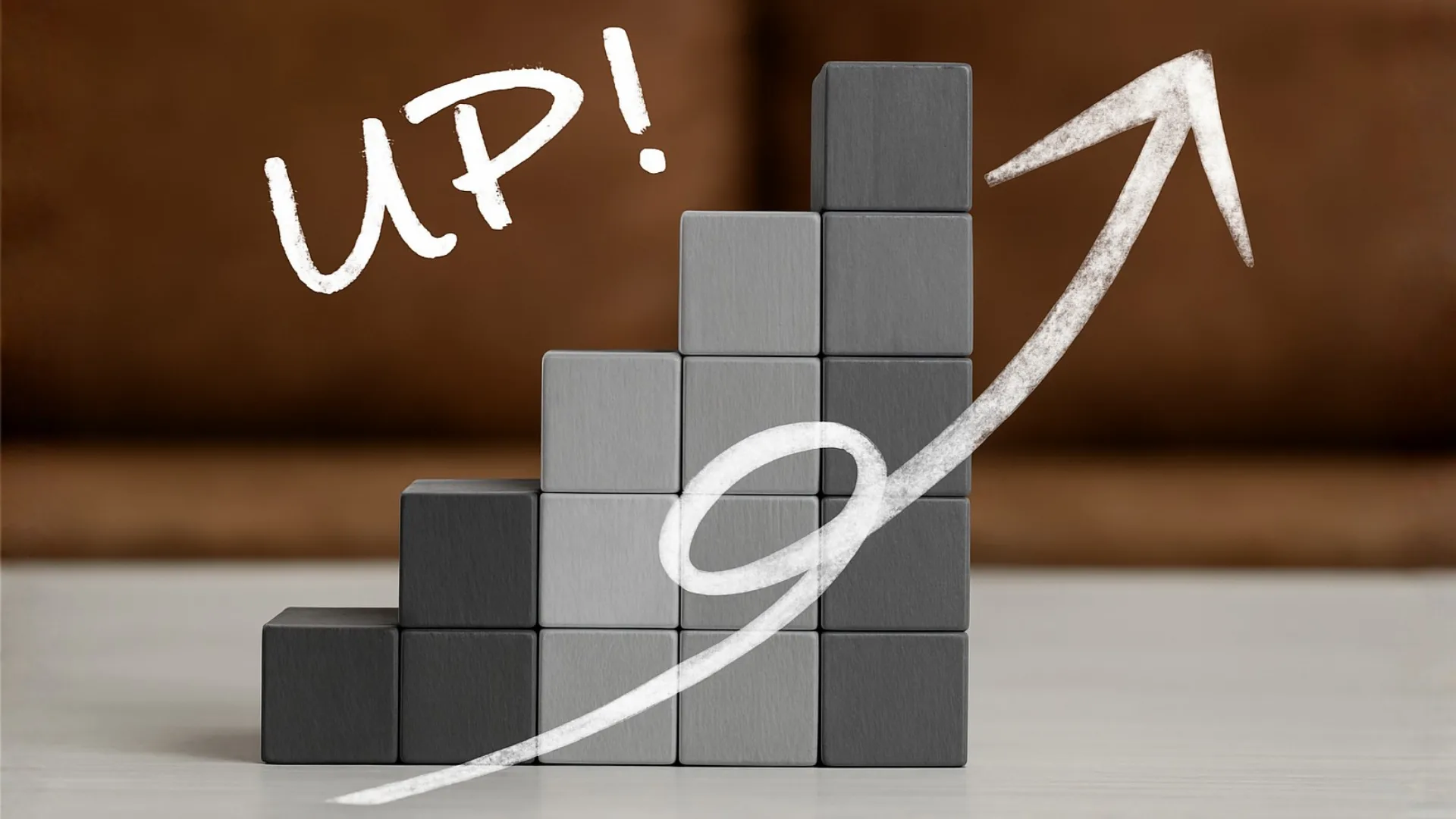 階段状に積まれた黒いブロックと、その上に手書き文字で「UP!」と描かれた上昇矢印。賃上げを意味する。