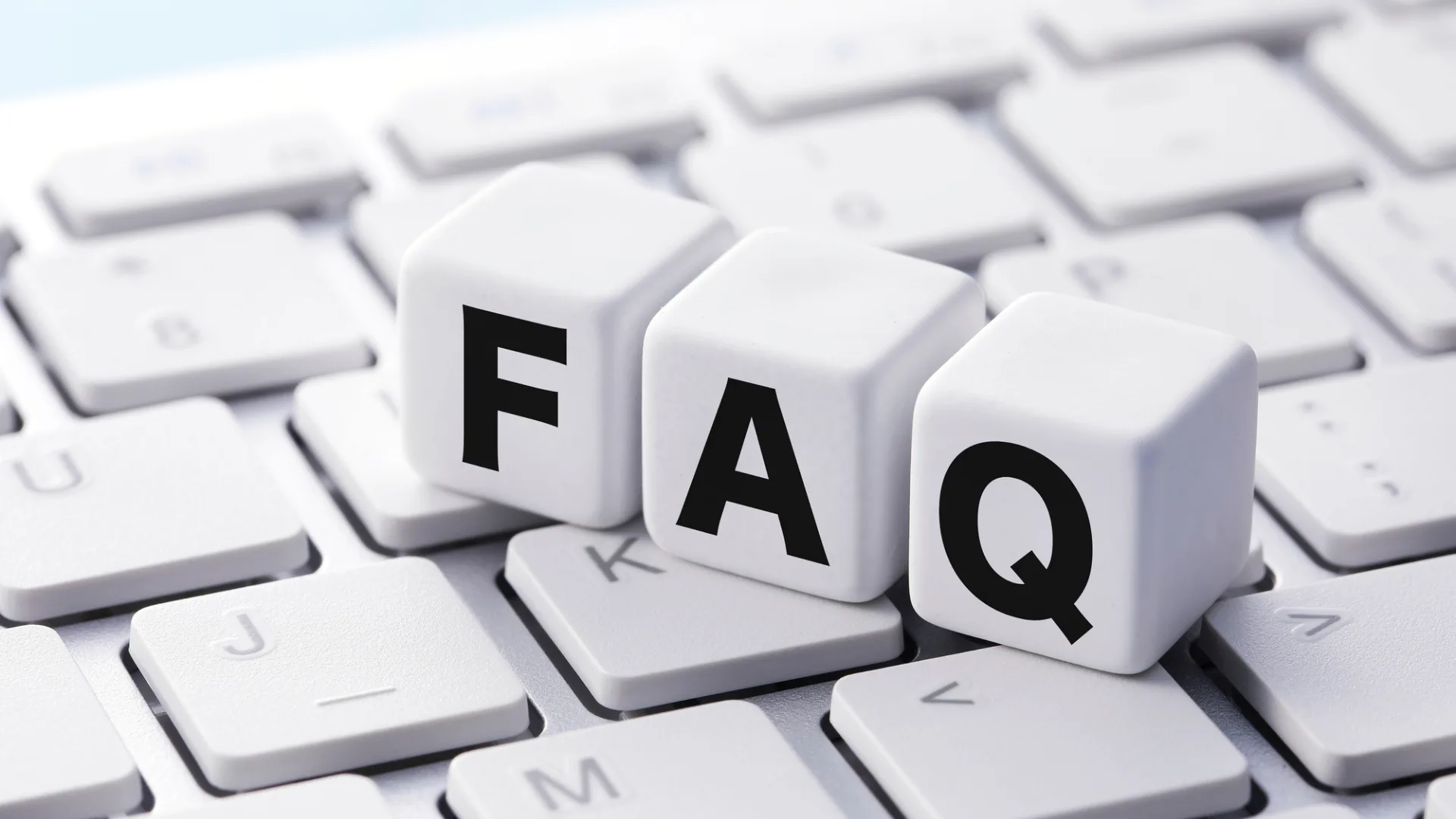 キーボードの上に「FAQ」と書かれたサイコロ型のブロックが並んでいる画像。