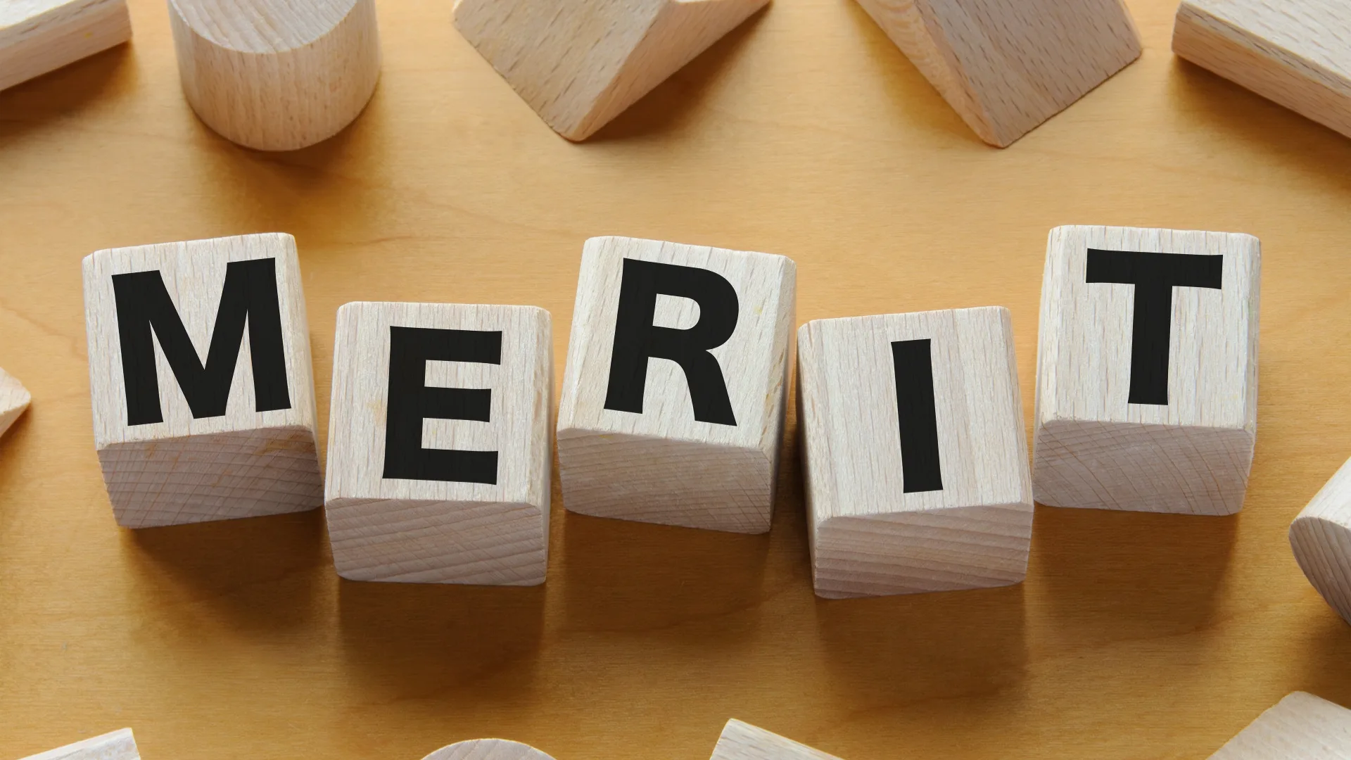 木製ブロックで形作られた「構成管理がもたらすMERIT(メリット)」という文字