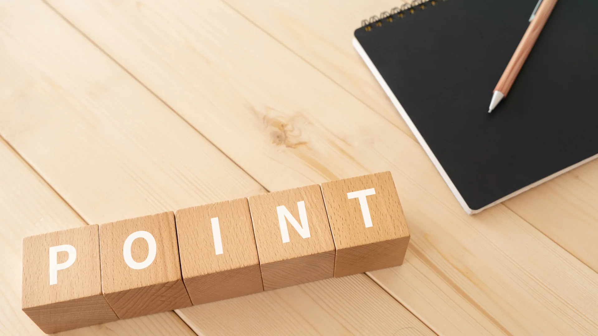 木製ブロックで「POINT」の文字とノート