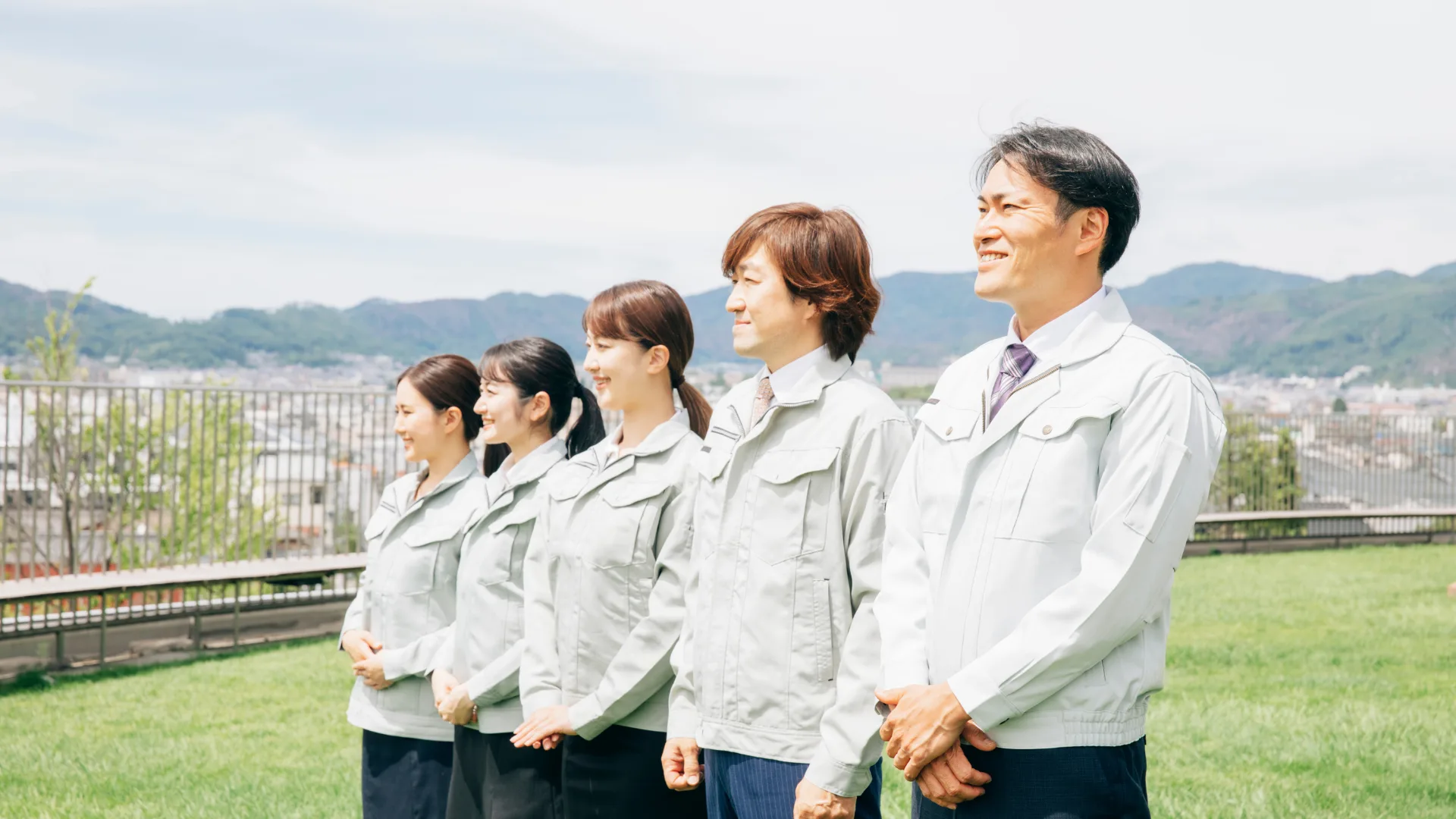 作業着を着て並び前を見つめる従業員、労働生産性に影響を与える要因