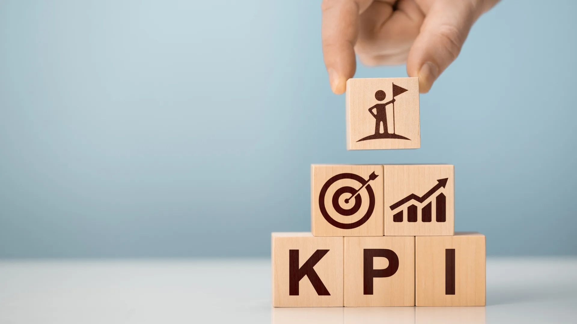 「KPI」のブロックと目標、成長、旗のアイコン。