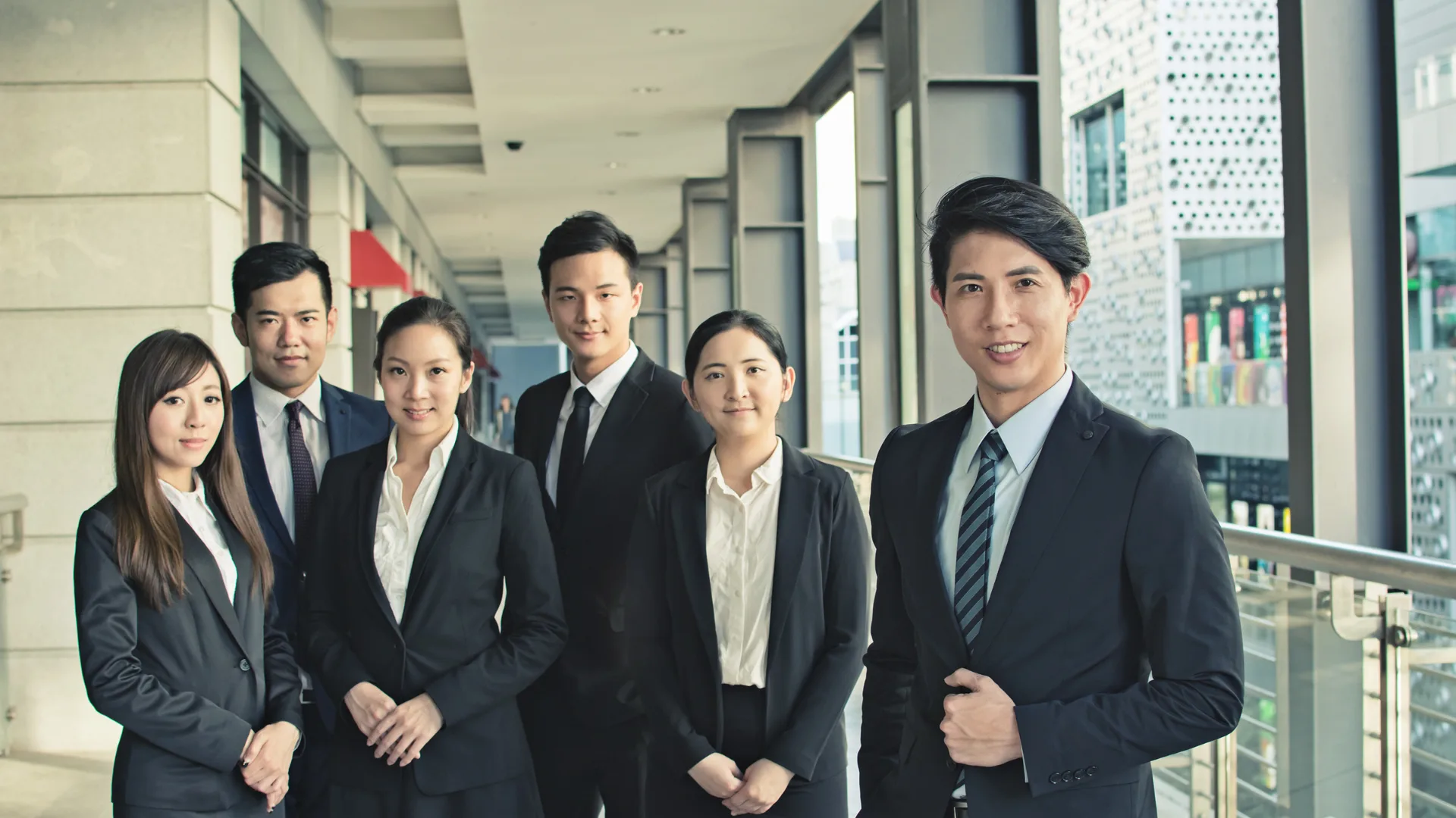 ビジネススーツを着た男女6人。労働分配率は産業によって違ってくる。