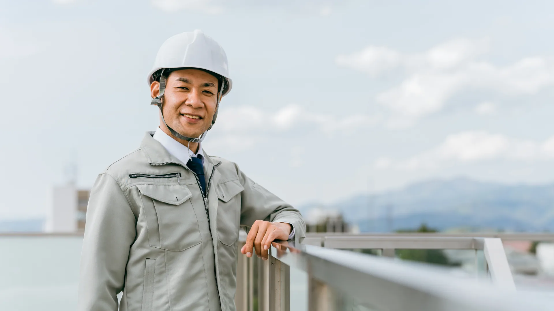 屋外で笑顔のヘルメット着用作業員