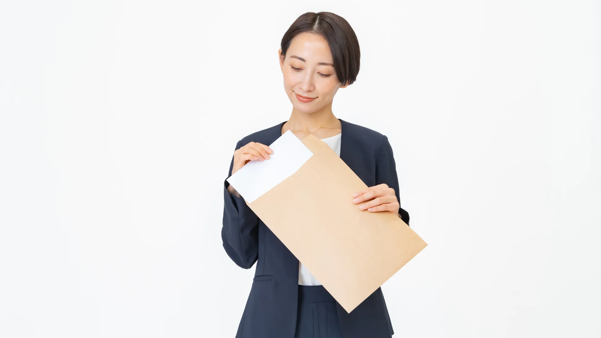 書類を茶封筒にしまう女性ビジネスパーソン。
